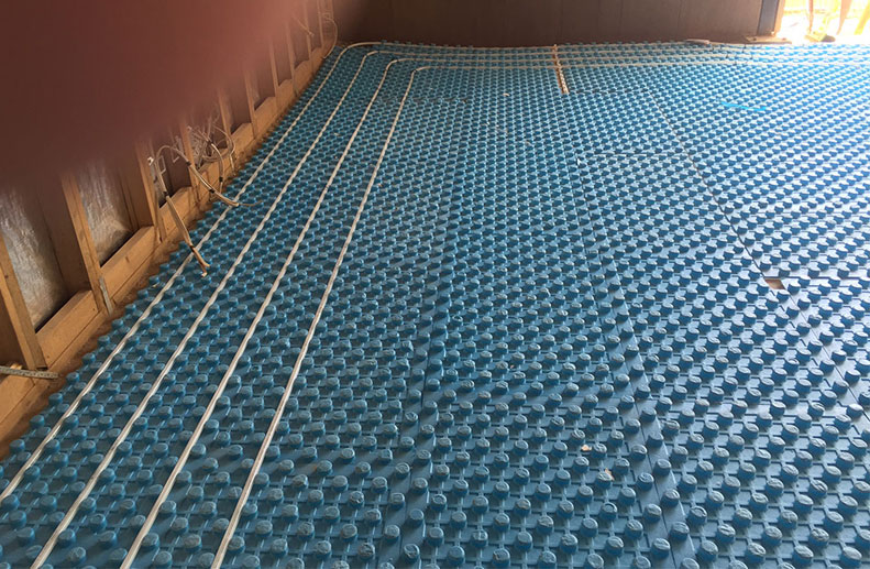 Blue Foam positioning board was used in this architecturally designed home with white Pex B Hydronic pipe. There were 2 Immergas Boilers, one for the downstairs In Slab (screed) installation and the other for the upstairs panels as the home was very large. Green paint indicates the construction joins within the slab and the kitchen bend and cabinets.