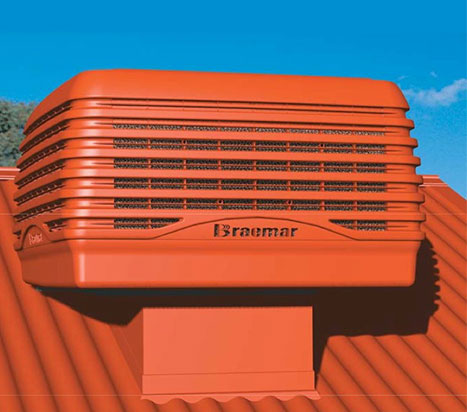bright red Braemar evaporative cooler on a red metal roof with bright blue sky in the background