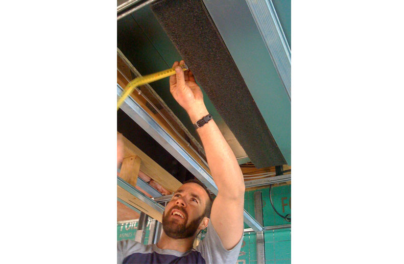 tradesman measuring for the fitting of fujitsu slimline bulkhead ducted unit installed in port melbourne with limited ceiling space with linear grilles