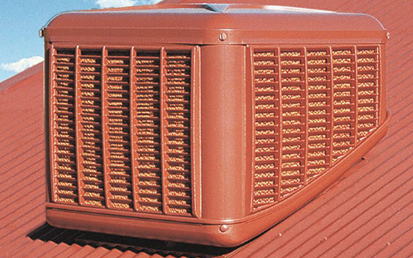 Coolbreeze red evaporative cooling system on a red metal roof against a blue sky with white clouds