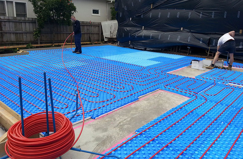 In Screed Hydronic Heating with Bosch boiler installed onto blue foam insulation board with red rehau pipe in Ivanhoe with manifold and pressure gauge prior to polished concrete screed pour