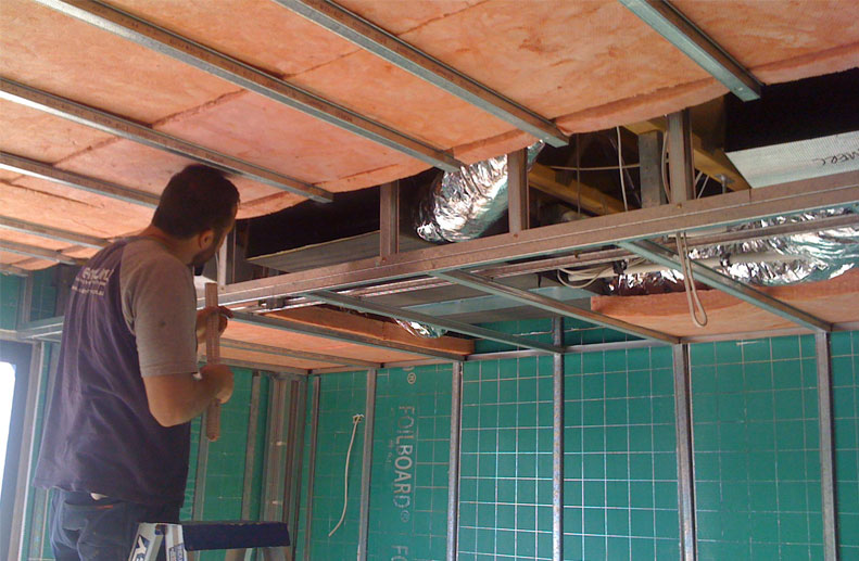 tradesman working on the installation of a Fujitsu slimline bulkhead ducted unit that was installed in post melbourne that had limited ceiling space and has linear grilles