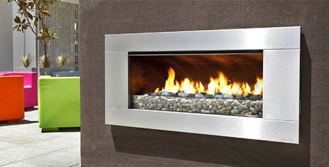 ESCEA EF5000_gas putdoor fireplace built into brown stone wall with silver border and a green, pink and orange chair in the background