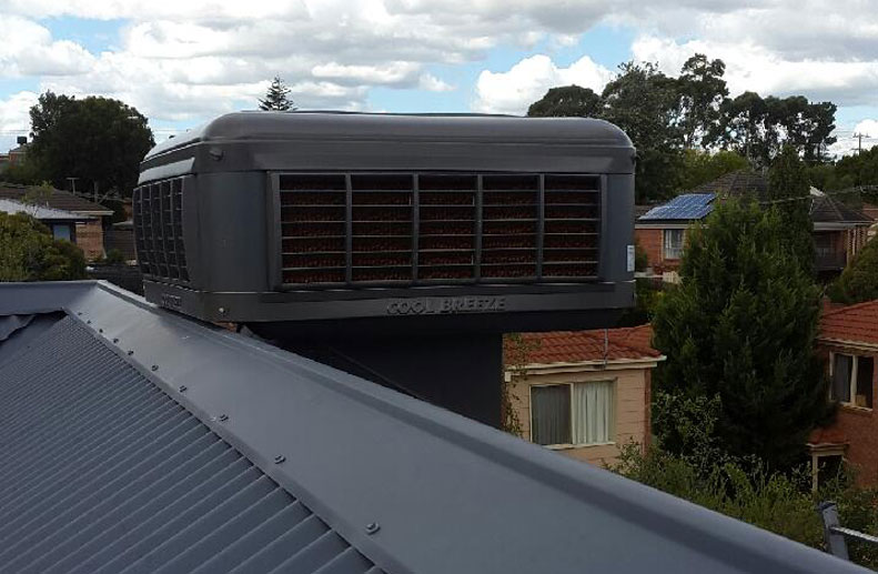 Coolbreeze Evaporative cooling being installed on a Colorbond roof - QAD 125 Slate Grey